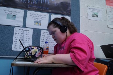 Bailey Graham looking at her laptop while wearing headphones.