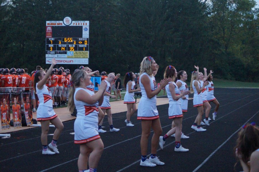 Varsity cheer team cheering to the crowd during the USA themed football game.