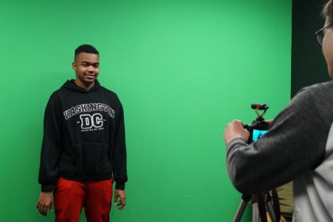 student in front of green screen.