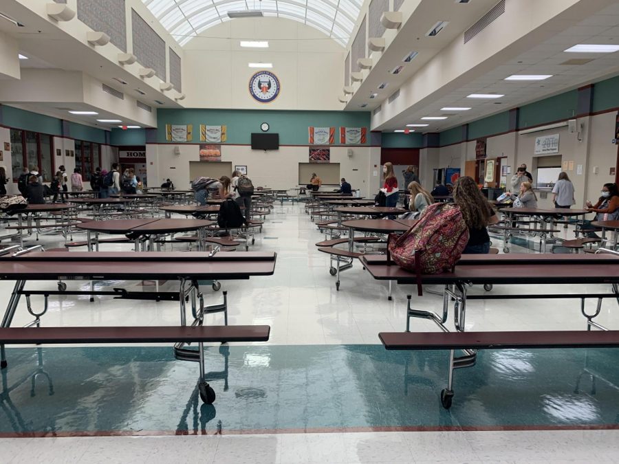 Photo of cafeteria with tables spaced six feet apart.