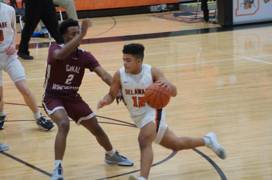 Hayes basketball player dribbles ball up the court. 