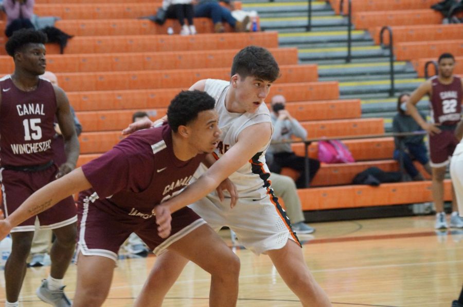 Hayes basketball player defends against a Canal Winchester player.