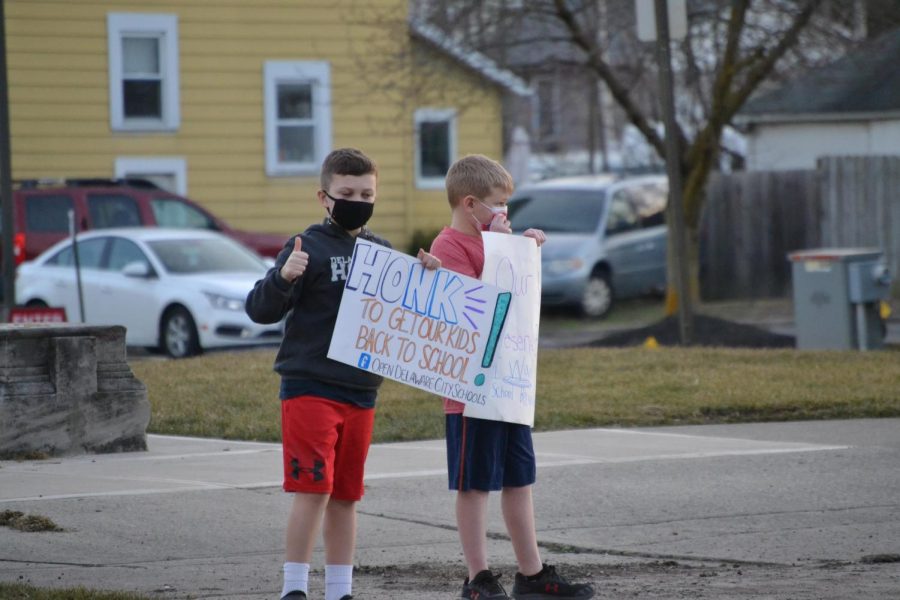 Two students participate in the protest on March 9, which was held in response to the Board of Educations decision to remain in a hybrid learning model for the rest of the year.