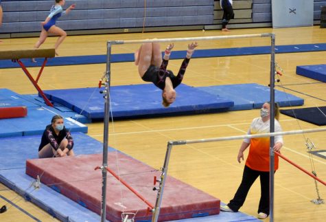 Girl flipping off of bars