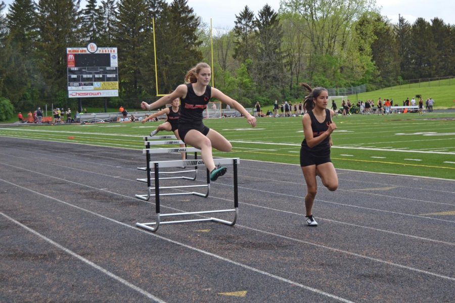 Senior Caylee Combs clears hurdle in 300 meter hurdles.