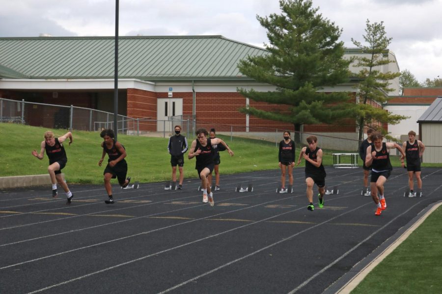 Multiple student athletes take off from starting line