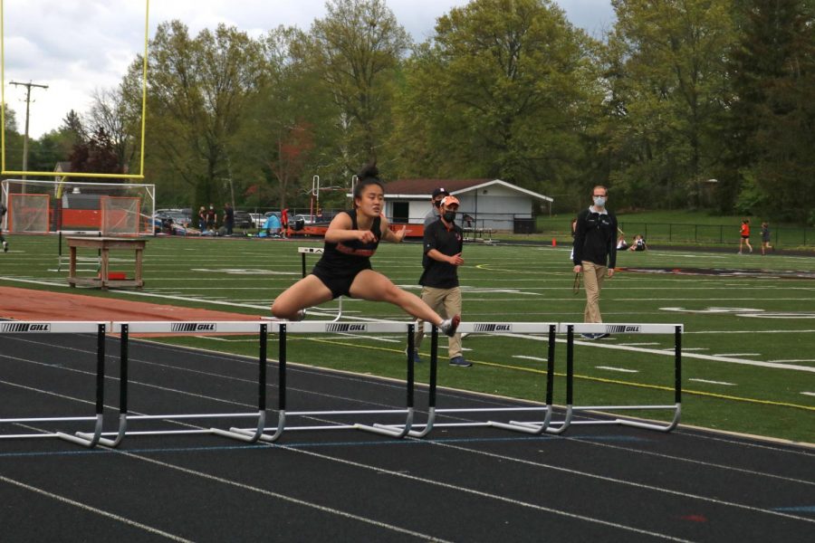 Runner jumps over hurdle