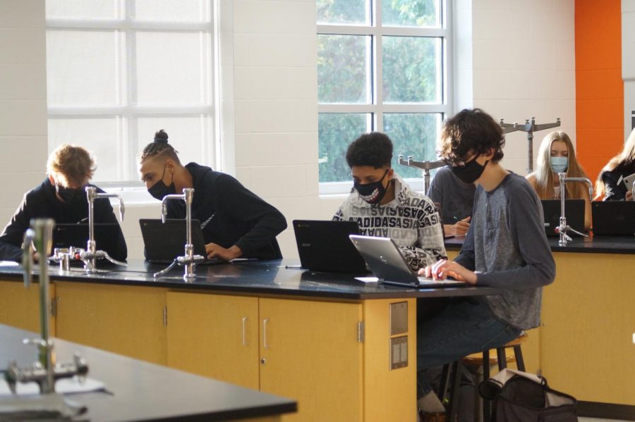 Students work during Keith Buttss physical science class.  Students are required to wear masks at all times inside the building, except while at lunch.