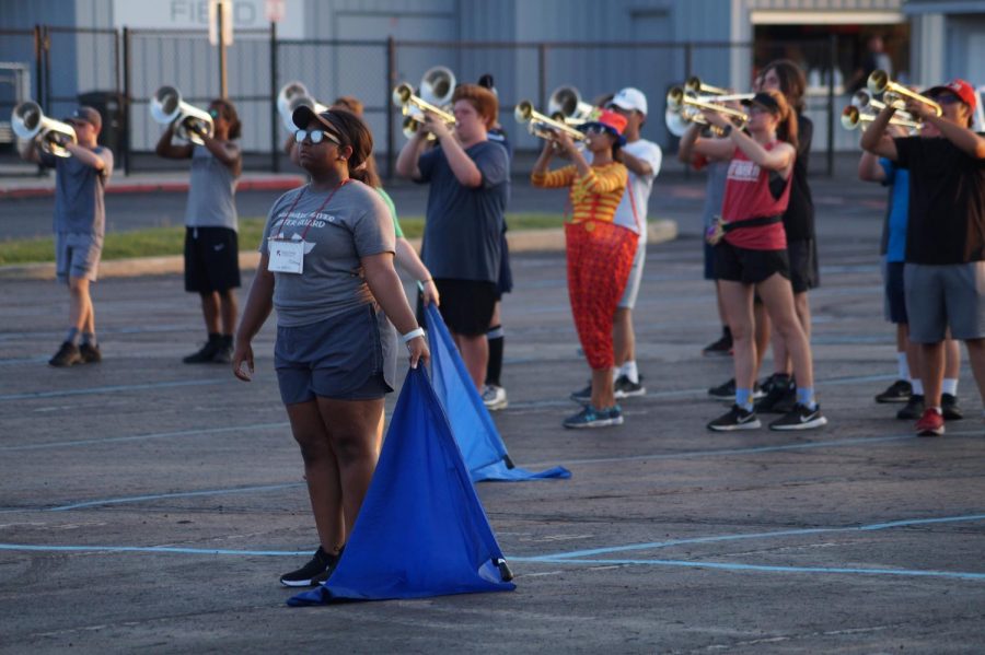 Senior Ava Johnson in color guard at the end of the set.