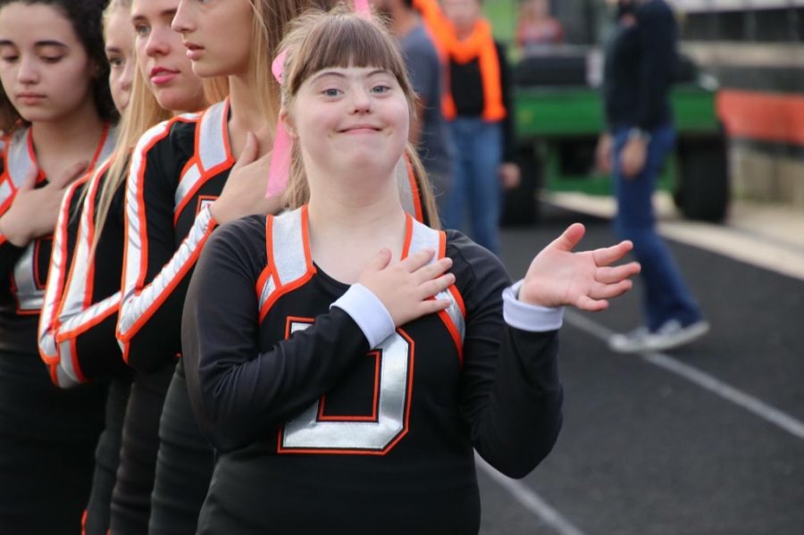 Katie Godfrey stands for the national anthem before she cheers on the Pacer football team.  Many students who are involved with the transition program also participate in sports and other extra-curricular activities.