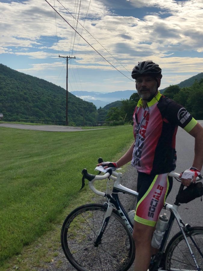 Lehman poses with his bicycle at the top of a hill.