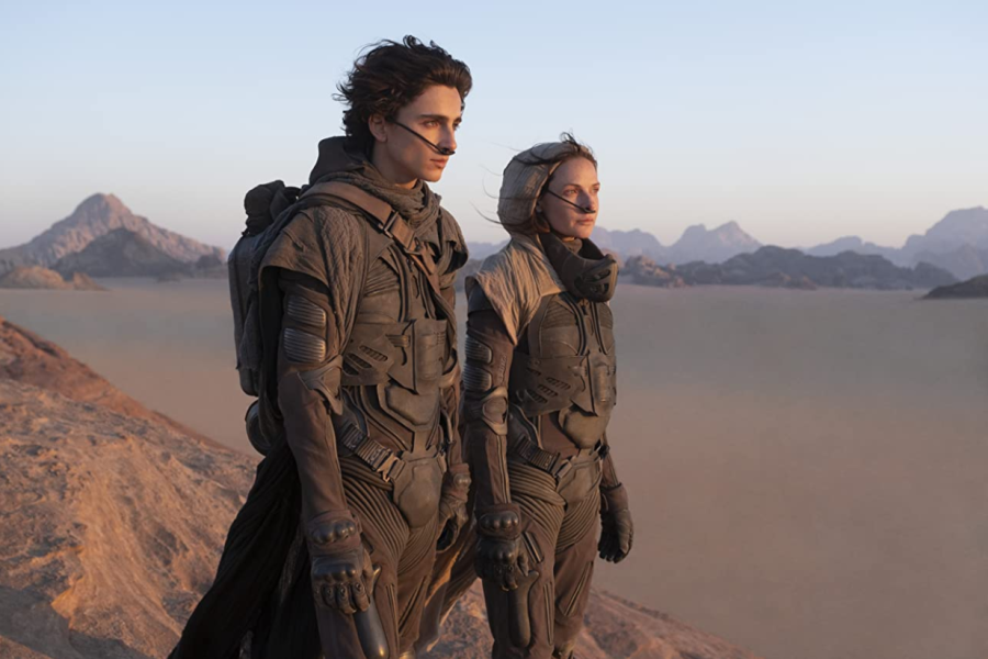 Paul (Timothée Chalamet) and Lady Jessica Atreides (Rebecca Ferguson) look across the desert planet of Arrakis in Dune. The film is now playing in theaters, and available to stream on HBO Max.