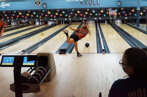 Girl throws bowling ball