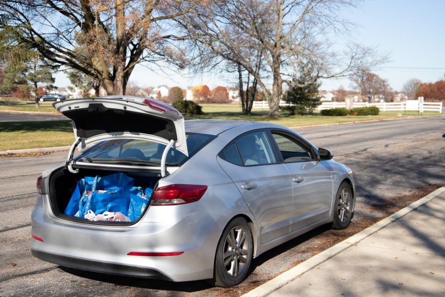 A car with a trunk full of food pulls up to the next station.