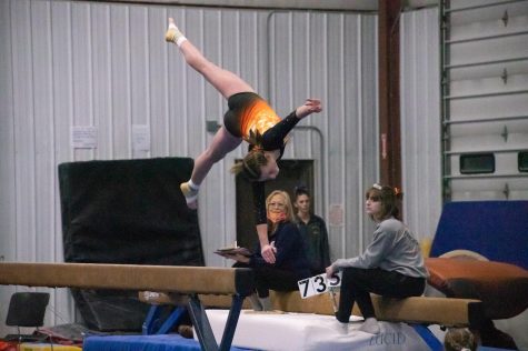 Gymnast flips off the beam.
