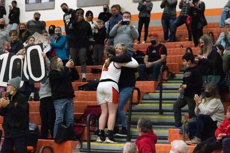 Senior Chloe Jeffers runs up the bleachers to hug her mom after scoring her 1000th point.