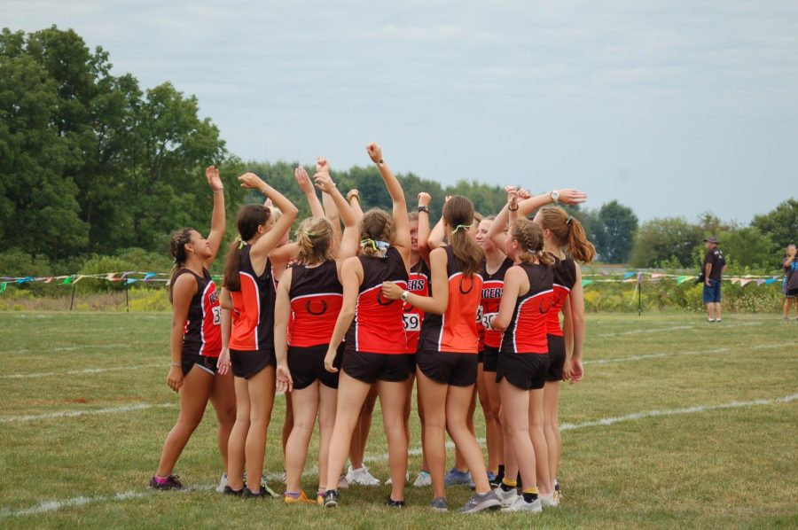 Girls cross country runners huddle for a pep talk before their race begins.
