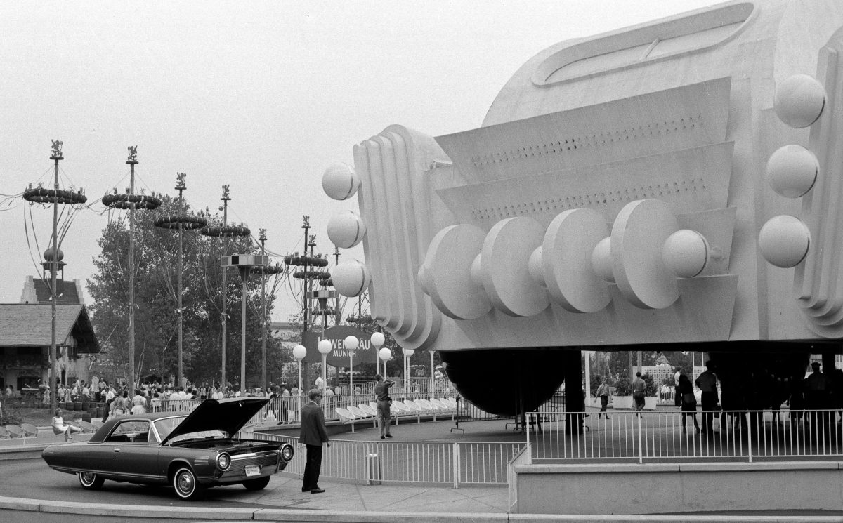 A Chrysler Turbine sits on display next to a faux car model during the 1964 World Fair. The Turbine was the most famous product of Chryslers turbine program.