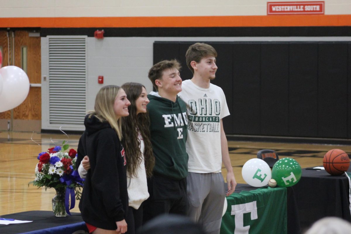 The four senior athletes pose for a picture after signing off at their future colleges.
