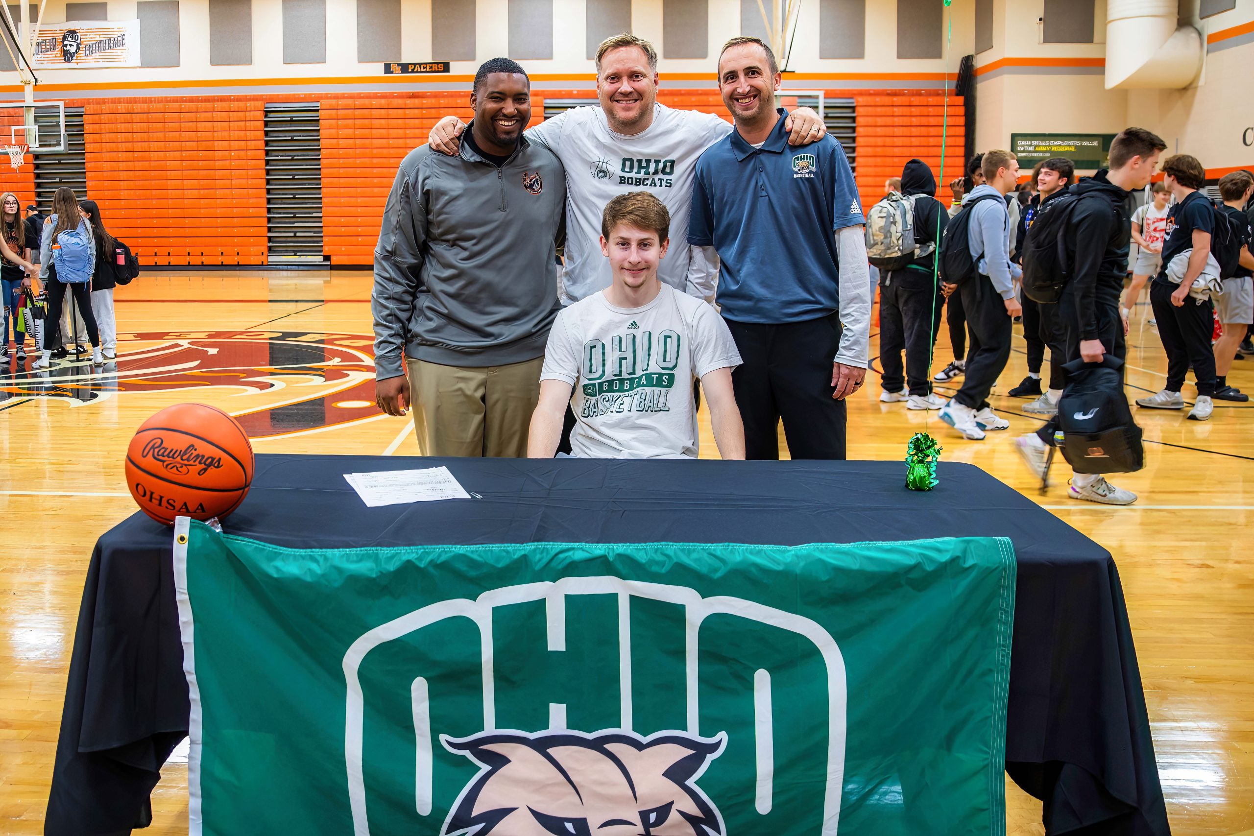 Coaches Keith Butts, Rob Price and Adam Vincenzo stand behind Jesse Burris after he signed to play basketball at Ohio University.