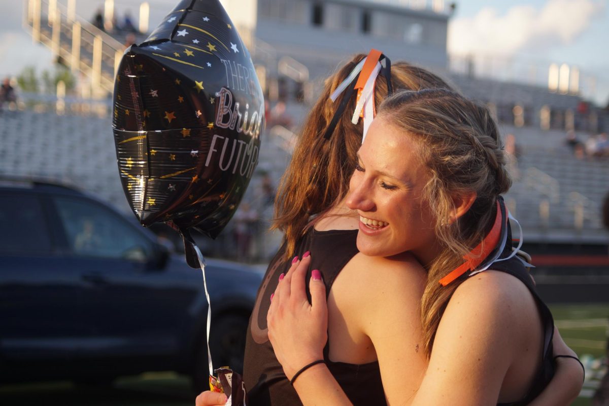 Senior Sammy West hugs Sophomore Paige Keller as she gives her a gift.  