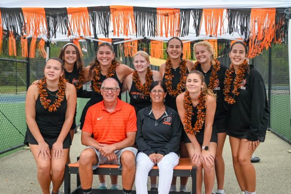 The seniors pose alongside their coaches before senior night ceremonies.