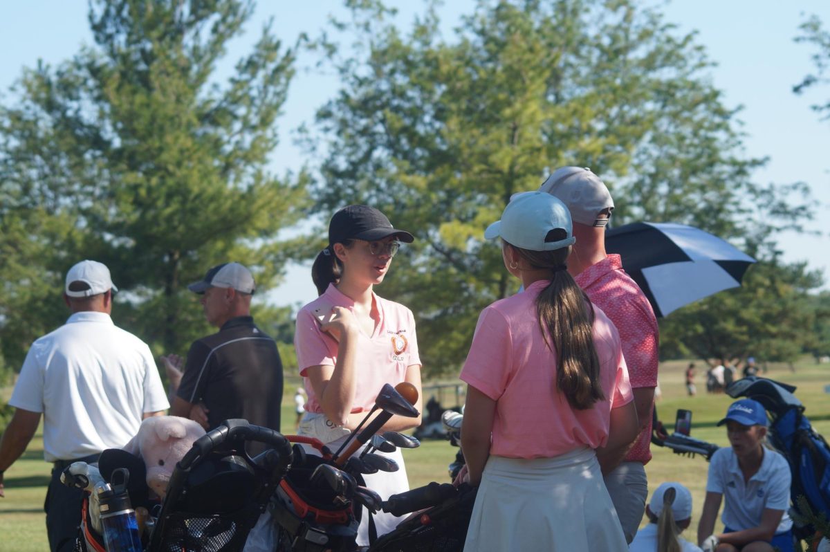 Junior Maggie Bixler and Sophomore Nevaeh Hess talk game plan with Coach Kitts