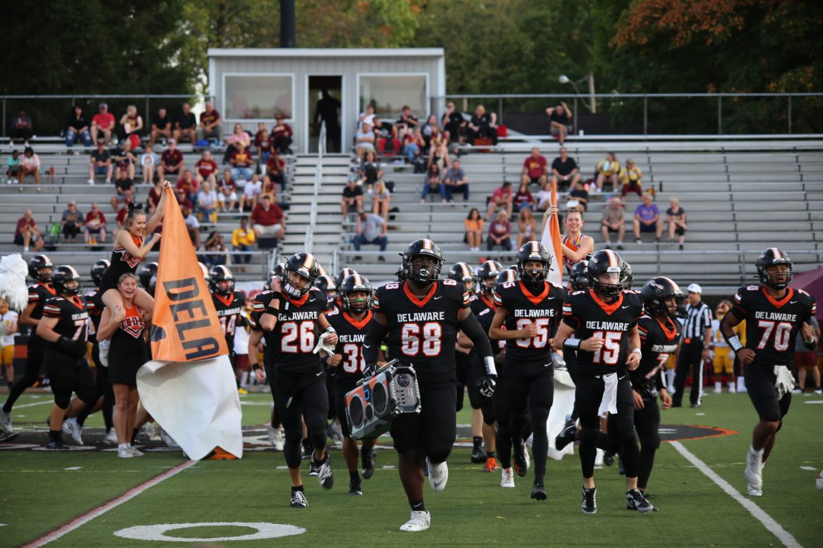 Senior Bilal Tucker leads the Pacers out through the banner to start the game.