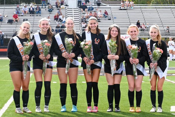 The seniors stand together and pose a for a picture.