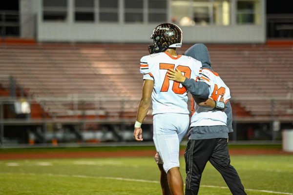 Watkins walks off the field with Collins comforting each other.