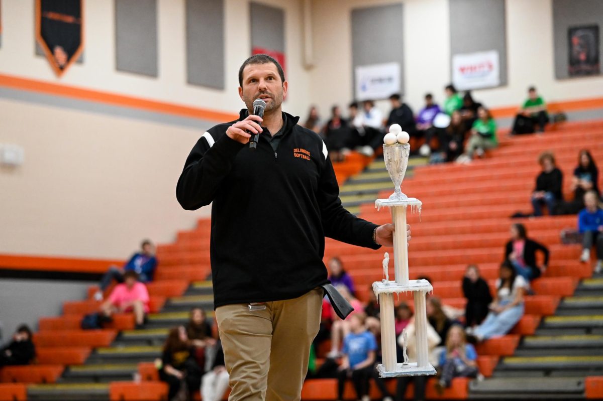 Assistant principal Jake Shafer prepares to hand the Ice Games trophy to this year's winning House.