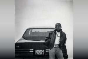 Rapper Kendrick Lamar leans against the trunk of a 1987 Buick Grand National Experimental, also known as the GNX, which calls back to the title of the album.