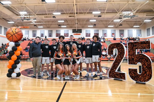 Both the cheerleaders and basketball seniors pose for an image.