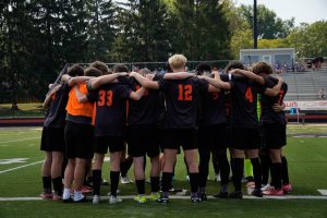 The soccer team huddles before the game.