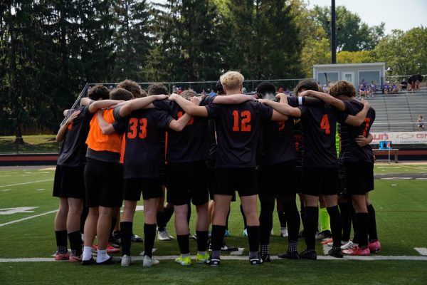 The soccer team huddles before the game.