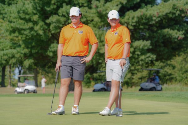 Seniors Maximo Morales and Zack Sanson watch as their pairings finish putting.