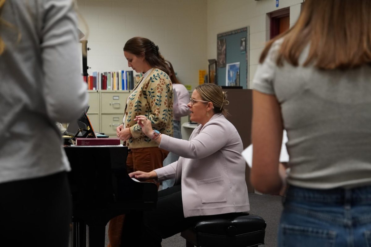 Choir director Tracy Cinereski leads her students in a new piece.