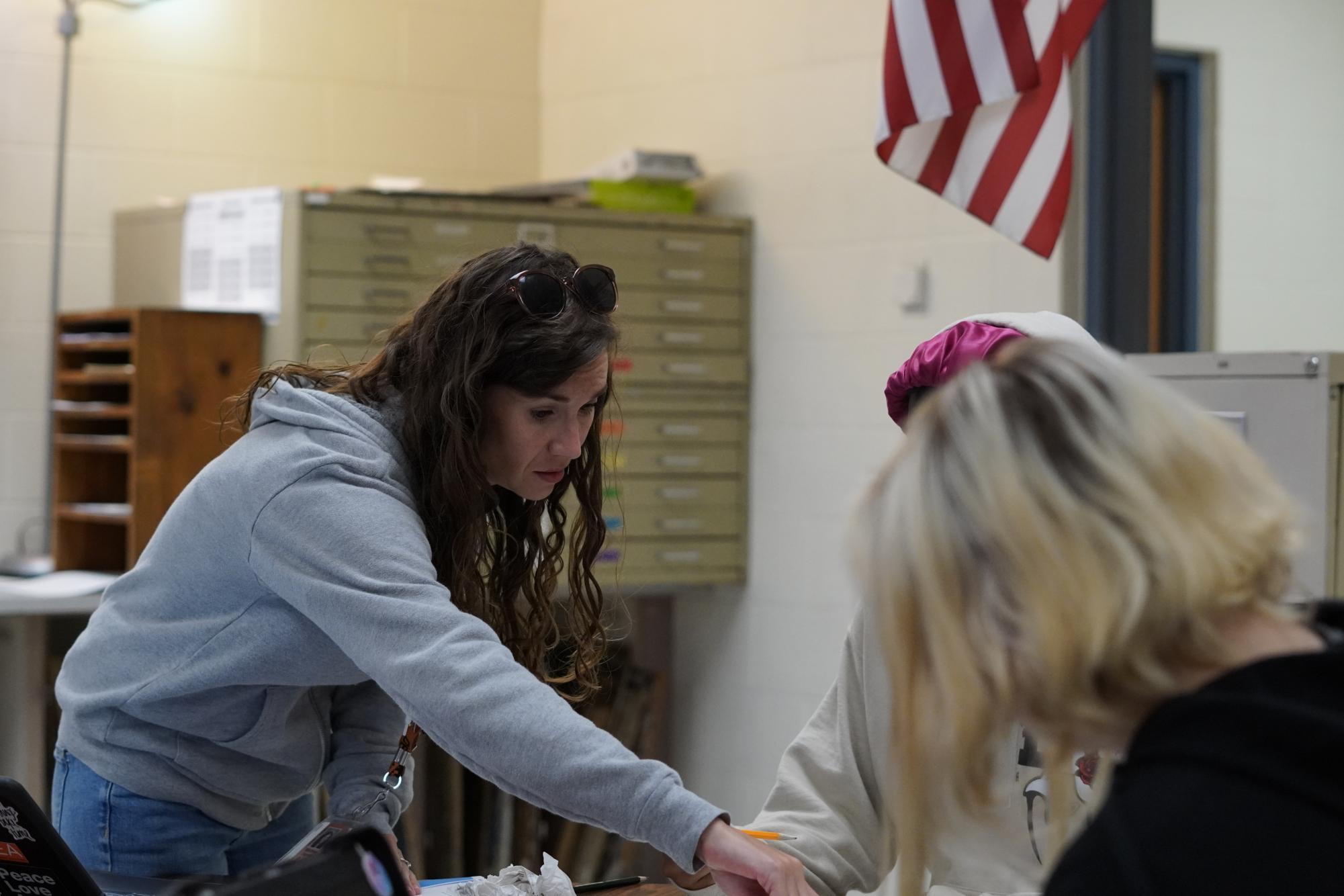 New art teacher Whitney Farrell helps a student with an assignment.