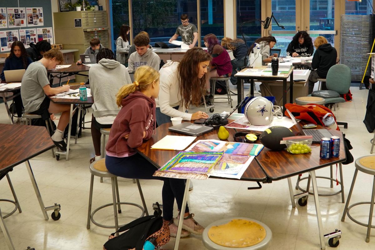 New art teacher Whitney Farrell helps a student with their work.