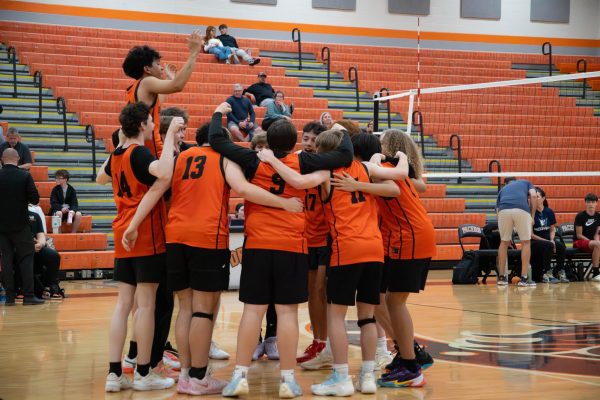 The team huddles together after a set.