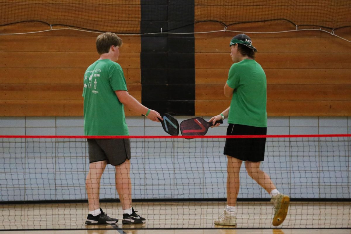 Sophomore Xander Howard touches paddles with his teammate after scoring a point.